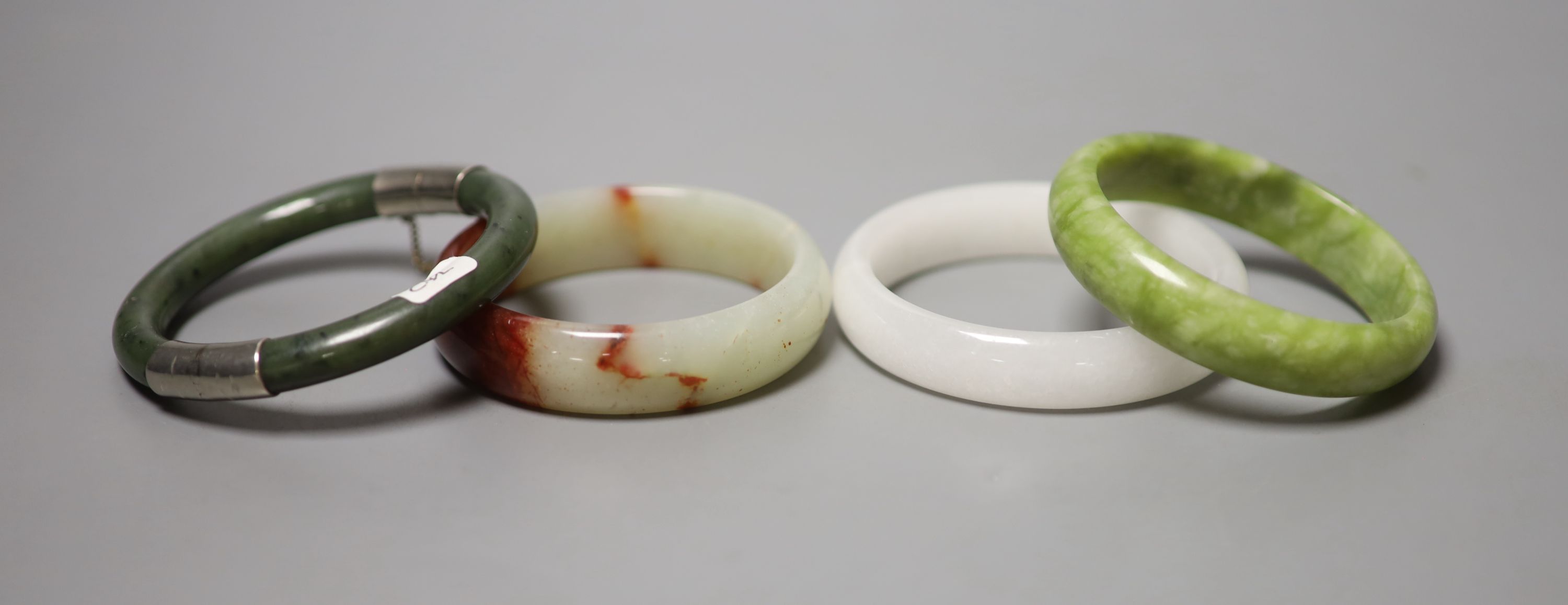 Four Chinese jade or hardstone bangles